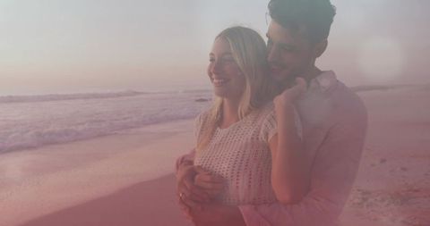 Couple Embracing on Pastel Sunset Beach with Reflective Wet Sand and Visible Ring