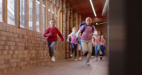 Energetic Schoolchildren Rushing Down Bright School Corridor