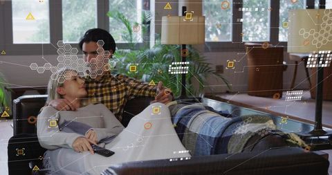 Couple cuddling on sofa watching tv with augmented reality interface overlay