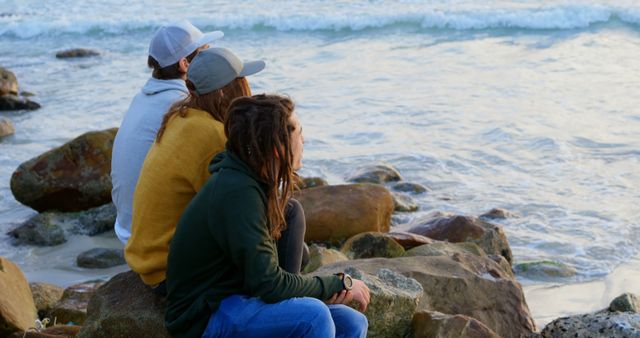 Friends Enjoying Relaxing Moments by Sea on Rocky Beach - Download Free Stock Images Pikwizard.com