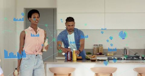 Couple preparing burgers in modern smart kitchen with holographic data analytics overlays