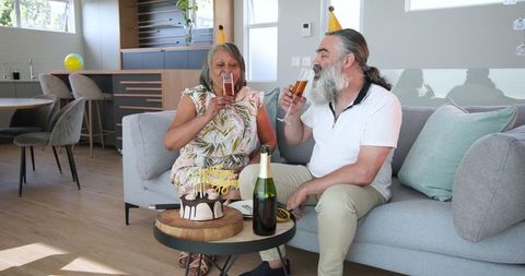 Senior Couple Celebrating Birthday with Champagne at Home
