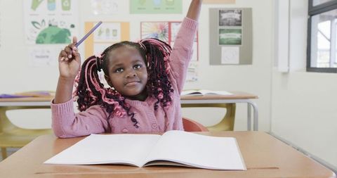 Enthusiastic Student Raising Hand in Classroom During Lesson