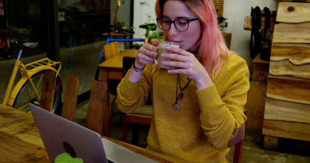 Young Woman with Pink Hair Working on Laptop While Drinking Coffee at Cozy Cafe - Download Free Stock Images Pikwizard.com