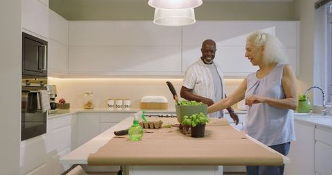 Senior Couple Planting Seedlings on Modern Kitchen Island