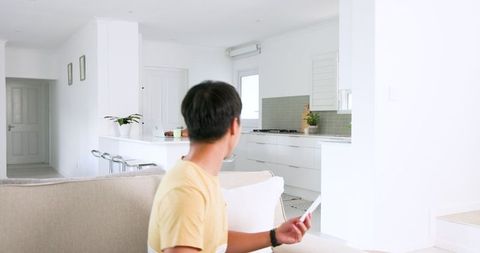 Man reading letter on sofa expressing joy in modern home