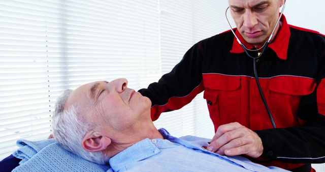A middle-aged Caucasian paramedic is checking the vital signs of a senior Caucasian man, with copy space. The paramedic's focused expression and use of a stethoscope suggest a medical emergency or health assessment scenario.