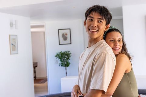 Young couple hugging in bright modern living room showing affection and home comfort