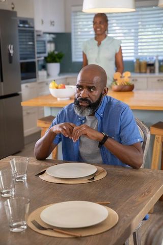 African American Couple Contemplative at Dining Table Preparing for Meal