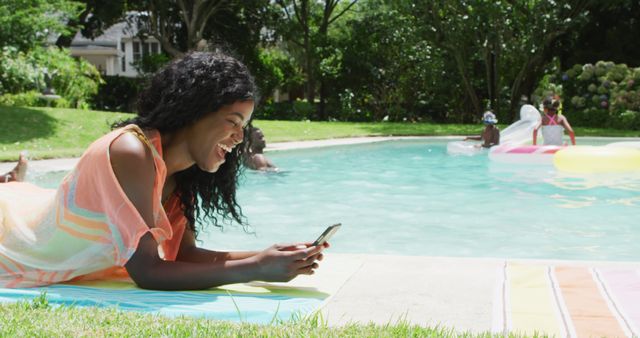 Happy african american woman relaxing at pool with family, using smartphone - Download Free Stock Photos Pikwizard.com