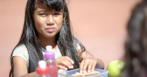 Schoolgirl Enjoying Lunch Outdoors on Sunny Day