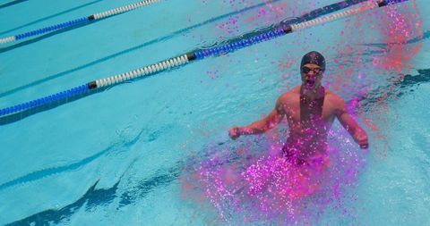 Dynamic Swimmer Emerging with Energetic Pink Surge in Competition Pool