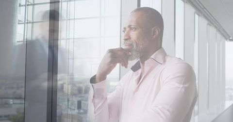 Pensive Businessman Overlooking Modern Cityscape