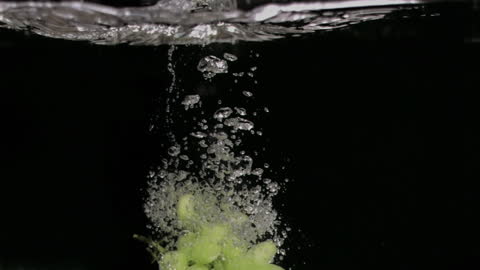 Green Grapes Splashing in Water with Slow Motion Bubbles