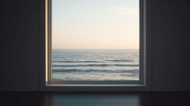 Framing large window revealing calm sea horizon, minimalist interior with warm light