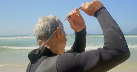 Senior Surfer Preparing at Beach in Wetsuit