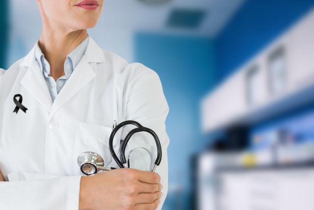 Female doctor is standing in a modern clinic wearing a stethoscope and a black ribbon. Perfect for use in healthcare promotional materials, awareness campaigns, hospital websites, medical blogs, and COVID-19 related content.