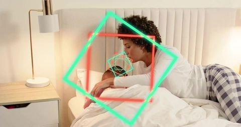 Parent tucking child into bed wearing plaid pajamas with neon geometric overlays