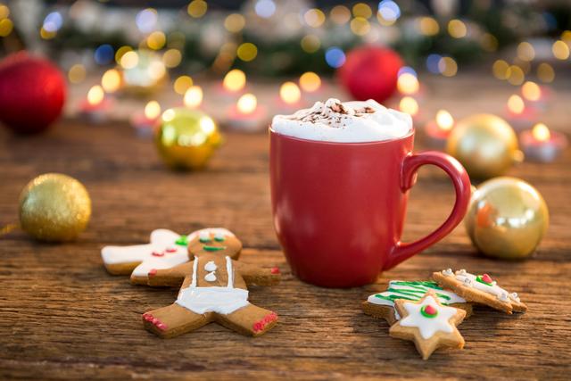 Coffee cup, sweet food, and gingerbread on wooden plank during christmas time