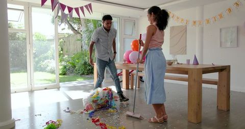 Couple Cleaning Up Confetti After Birthday Celebration at Home