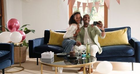 Joyful Couple Celebrating At Home With Wine and Cake