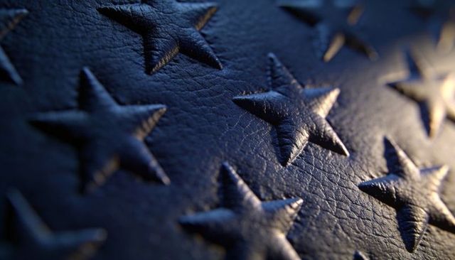 Macro close-up showing embossed navy leather with raised five-pointed stars and grain highlights