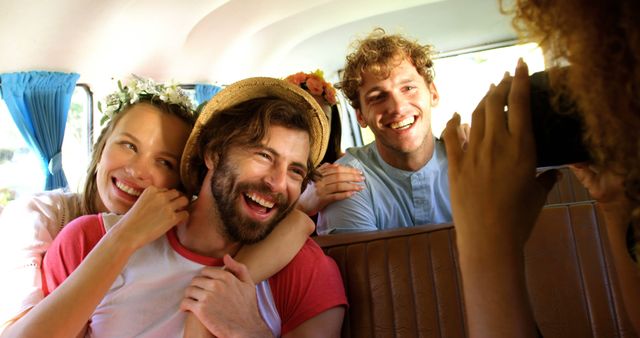 Group of friends enjoying road trip in a van, smiling and having fun. Ideal for travel blogs, adventure promotions, youthful lifestyle marketing, and social media content emphasizing friendship and joy.