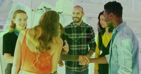 Diverse team shaking hands during collaborative office meeting with growth chart overlay
