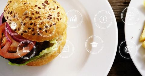 Sesame bun burger sitting on white plate with futuristic digital ui icon overlay