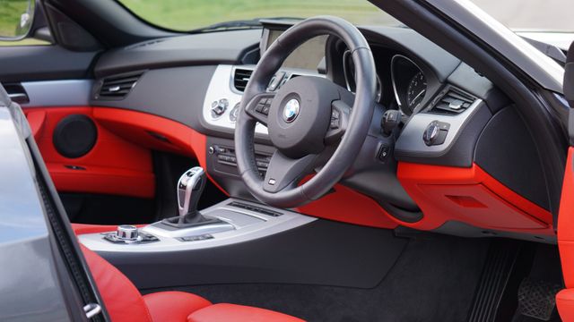 Modern and luxurious sporting car interior featuring red and black leather seats and advanced dashboard. Ideal for marketing and promotional use in automotive industry advertisements. Picture is excellent choice for illustrating luxury lifestyle, car design concepts, technology showcases, and automotive detailing services.