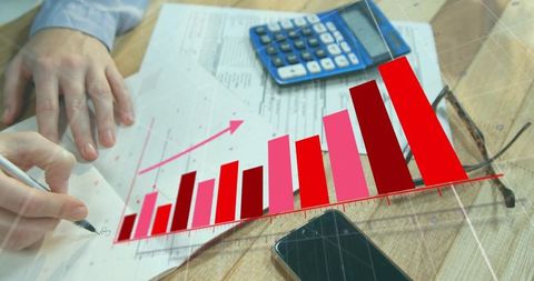 Hands annotating financial documents with rising bar graph overlay for revenue growth