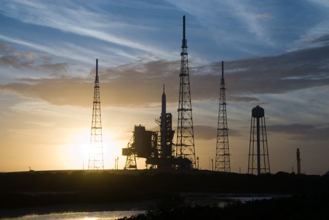 Silhouette of Ares I-X rocket at sunset on NASA's Launch Pad 39B, Kennedy Space Center, Florida, during Constellation Program. Ideal for illustrating topics related to space exploration, aerospace technology, NASA missions, and historical launches.