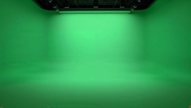 Green cyclorama studio with overhead lighting grid and seamless curved greenscreen