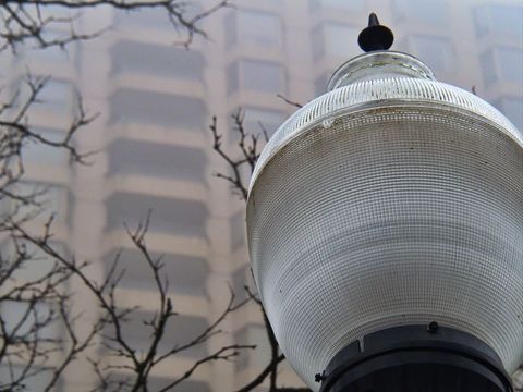Vintage street lamp against foggy cityscape design
