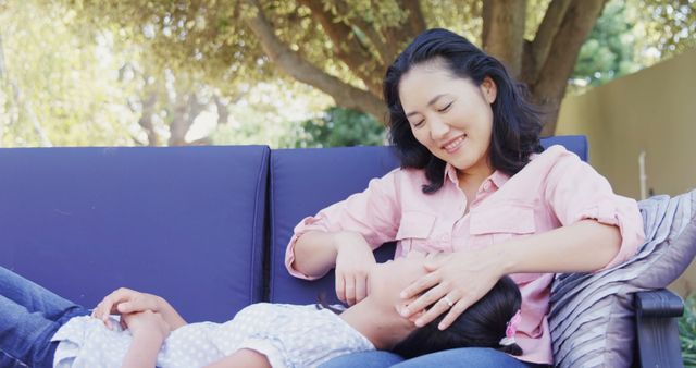 Mother Gently Cares for Daughter Relaxing on Outdoor Couch - Download Free Stock Images Pikwizard.com