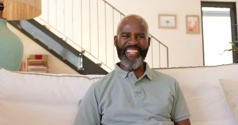 Senior Man Relaxing and Smiling on Couch at Home