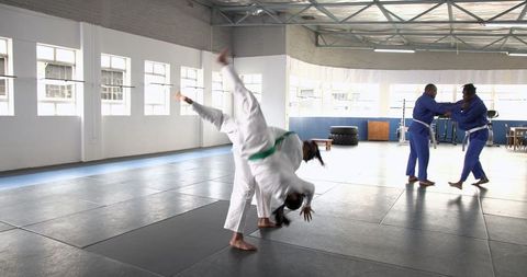 Martial Arts Training with Partners Executing Throws in Dojo