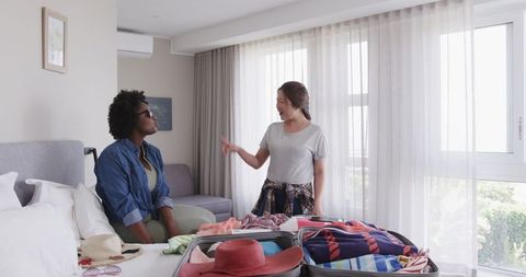 Interracial Couple Packing for Vacation in Modern Bedroom