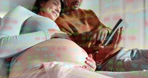 Expectant couple relaxing on couch using tablet with pregnancy belly and market overlay