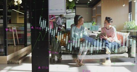 Colleagues analyzing digital data in modern office lounge