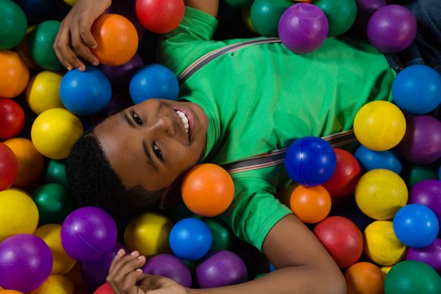 Overhead portrait of smiling boy in ball pool