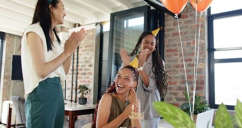 Diverse colleagues celebrating birthday in modern office