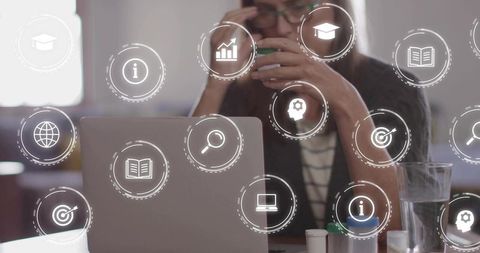 Woman Sipping Coffee While Working on Laptop with Digital Icons in Coworking Space