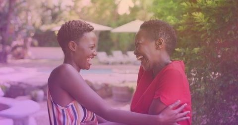 Happy Sisters Laughing Together at Outdoor Resort