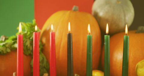 Festive Kwanzaa Candles Display with Pumpkins and Greenery