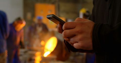 Worker using mobile technology in industrial workshop