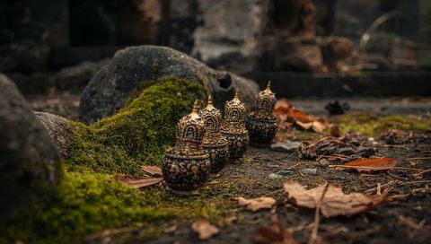 Antique Gilded Lidded Jars Resting on Mossy Stone Ruins with Fallen Leaves, Ornate Thai Vessels