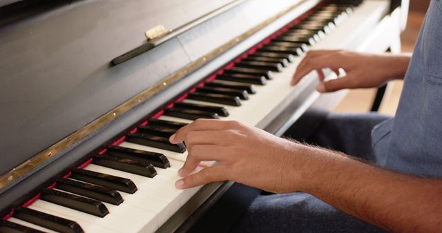 Biracial man playing piano at home. Instrument, music, relaxing, free time and domestic life concept, unaltered.