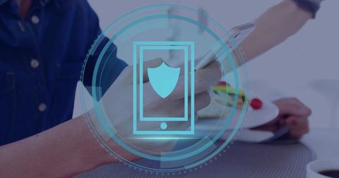 Mobile security concept showing shield HUD over smartphone being used at dining table