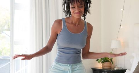 Happy Woman Enjoying Music in Cozy Bedroom with Natural Light
